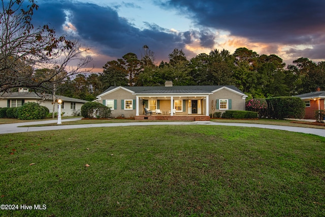 single story home featuring a lawn and covered porch