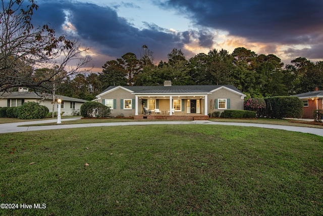 1831 Hawthorne Rd, Wilmington, NC 28403 - single story home with a porch, a front lawn, a chimney, and curved driveway