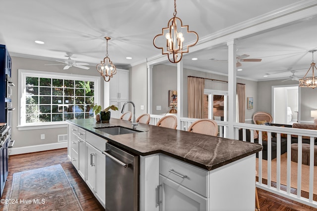 kitchen with a kitchen island with sink, crown molding, sink, white cabinetry, and hanging light fixtures