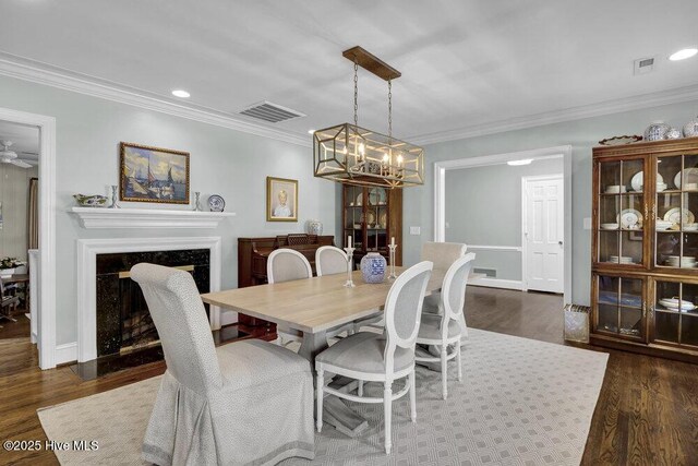 dining area with ornamental molding, dark wood-type flooring, and a chandelier