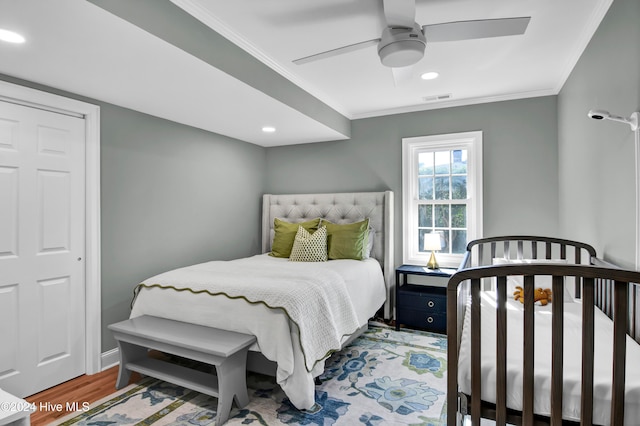 bedroom featuring wood-type flooring, ceiling fan, and crown molding