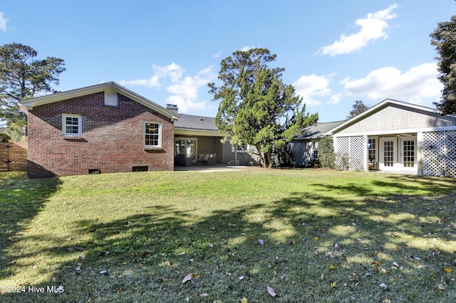 1831 Hawthorne Rd, Wilmington, NC 28403 - back of house featuring french doors, brick siding, a lawn, and crawl space