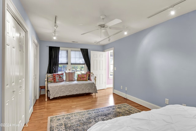 bedroom with ceiling fan, wood-type flooring, and track lighting