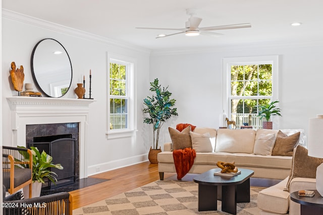 living room with ceiling fan, ornamental molding, and light wood-type flooring