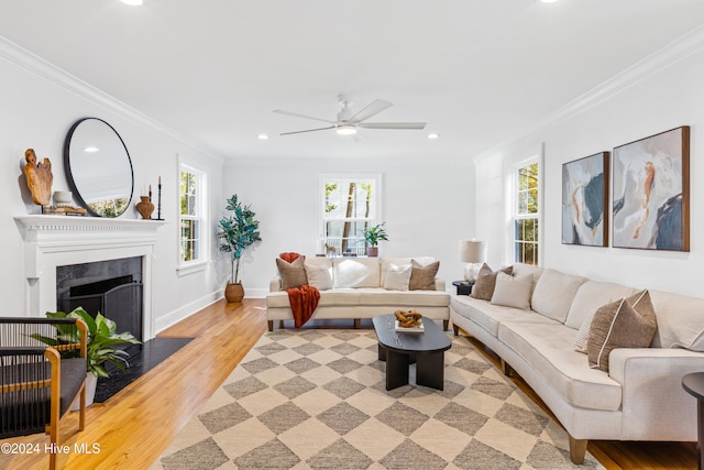 living room with light hardwood / wood-style flooring, ceiling fan, and ornamental molding