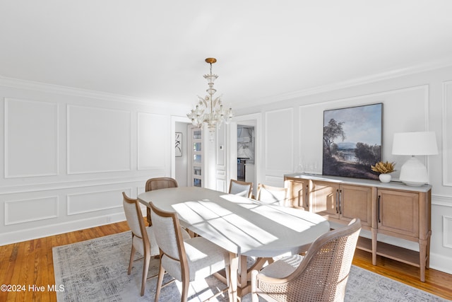 dining room with a chandelier, crown molding, and light hardwood / wood-style floors