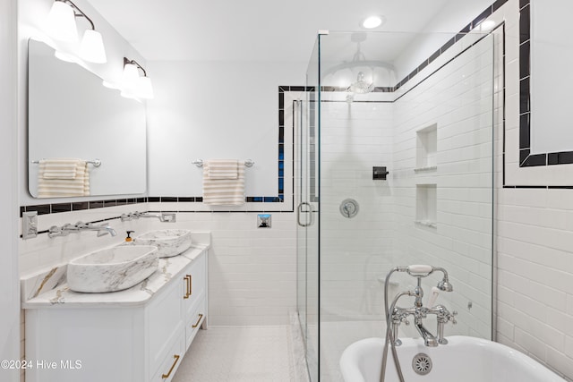 bathroom featuring separate shower and tub, vanity, and tile walls