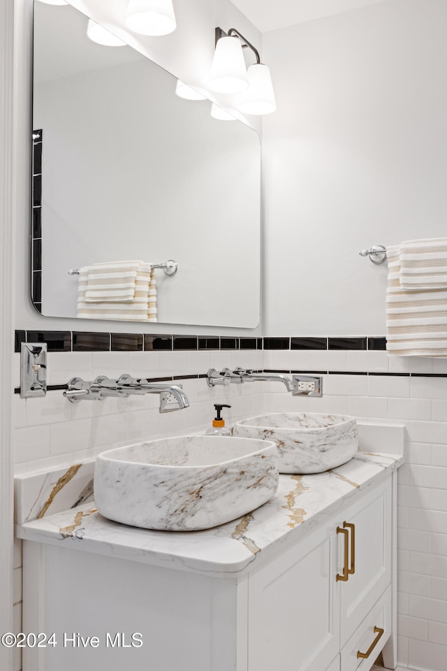 bathroom featuring vanity and tile walls