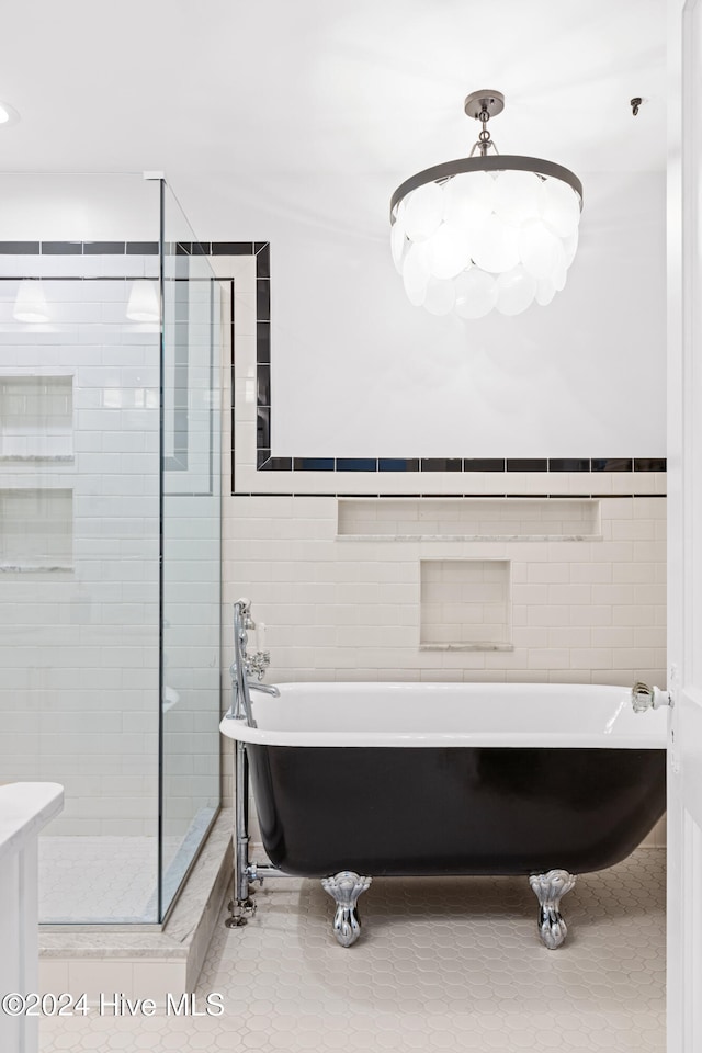 bathroom with a washtub, tile walls, and tile patterned flooring