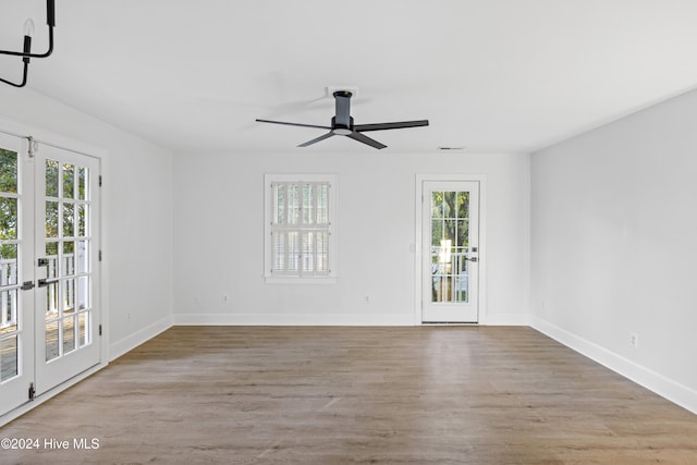 unfurnished room featuring plenty of natural light, ceiling fan, light wood-type flooring, and french doors