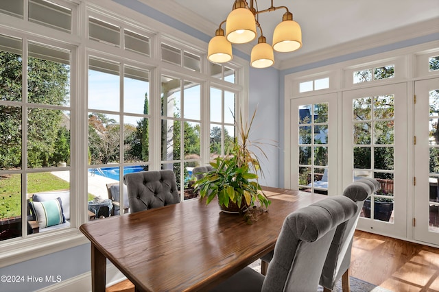 sunroom / solarium with plenty of natural light and a notable chandelier