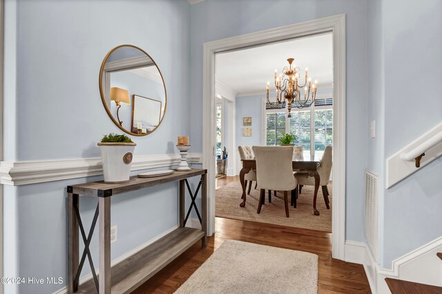 dining room with dark hardwood / wood-style flooring, a chandelier, and ornamental molding