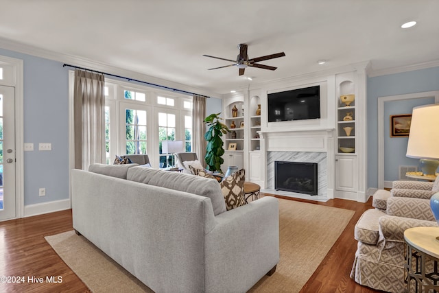 living room with dark hardwood / wood-style flooring, ceiling fan, crown molding, and a premium fireplace