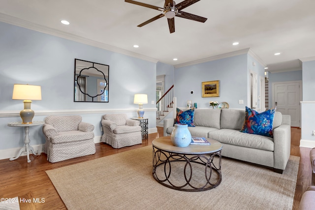 living room with hardwood / wood-style flooring, ceiling fan, and crown molding