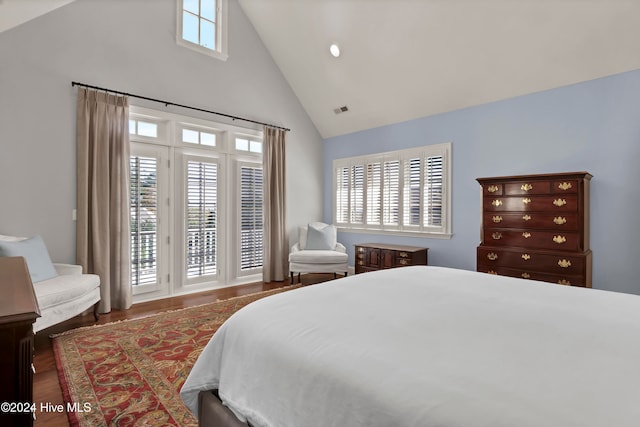 bedroom with high vaulted ceiling and dark wood-type flooring