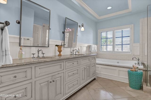 bathroom featuring a tray ceiling, a tub, crown molding, and vanity