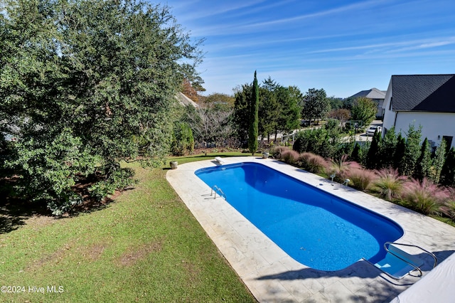 view of pool with a lawn and a diving board