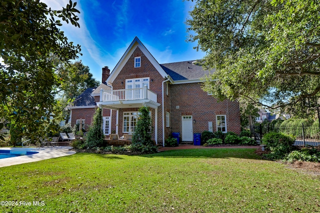 view of front of home with a front yard, a balcony, a patio area, and a fenced in pool