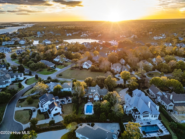 aerial view at dusk featuring a water view