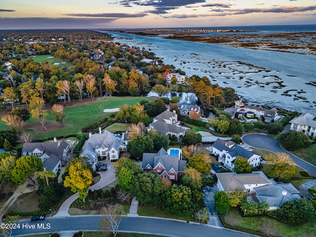 aerial view at dusk featuring a water view