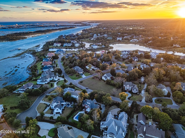 aerial view at dusk featuring a water view