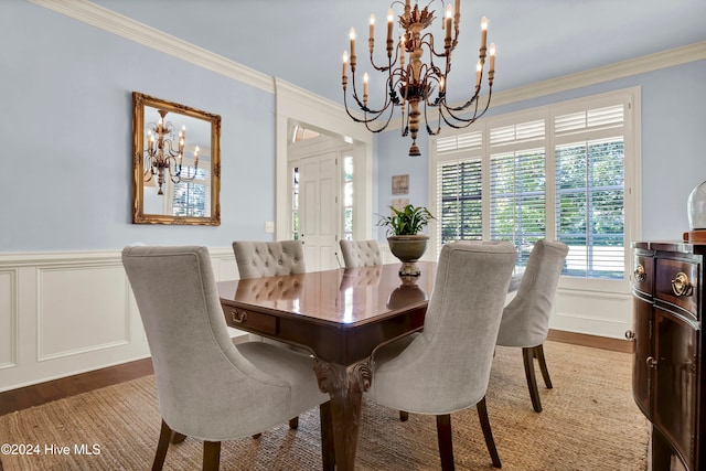 dining space featuring hardwood / wood-style flooring, ornamental molding, and a chandelier