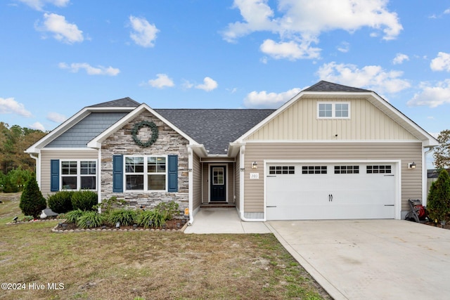 craftsman house featuring a garage and a front lawn