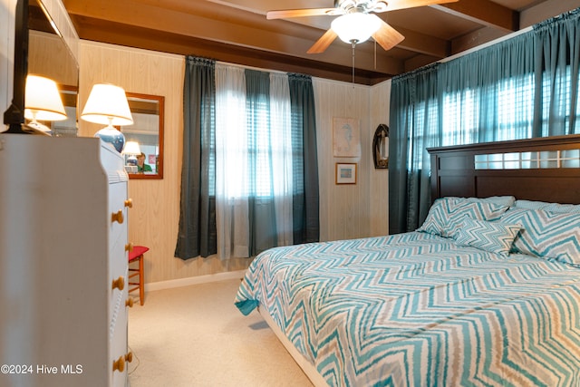 carpeted bedroom featuring ceiling fan and beamed ceiling