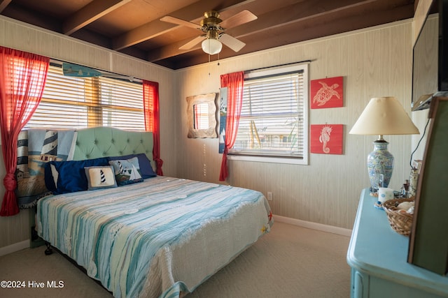 bedroom featuring beam ceiling, multiple windows, ceiling fan, and carpet