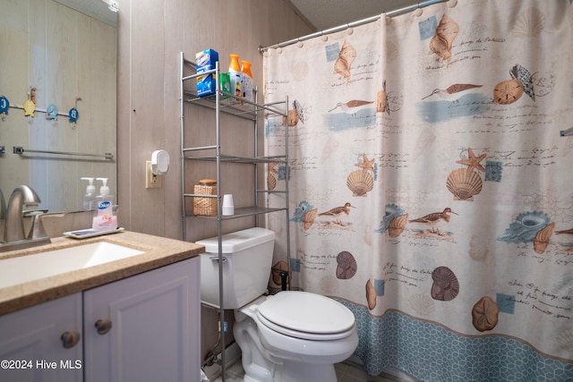 bathroom with a textured ceiling, vanity, toilet, and walk in shower