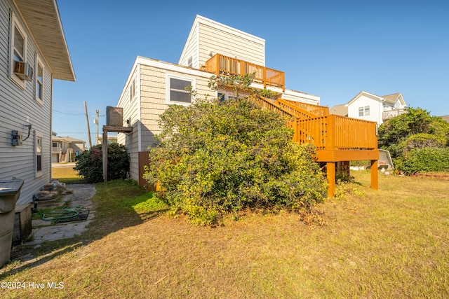 view of side of home featuring a wooden deck and a yard