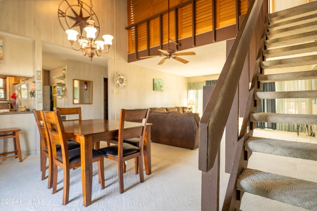 carpeted dining area featuring ceiling fan with notable chandelier