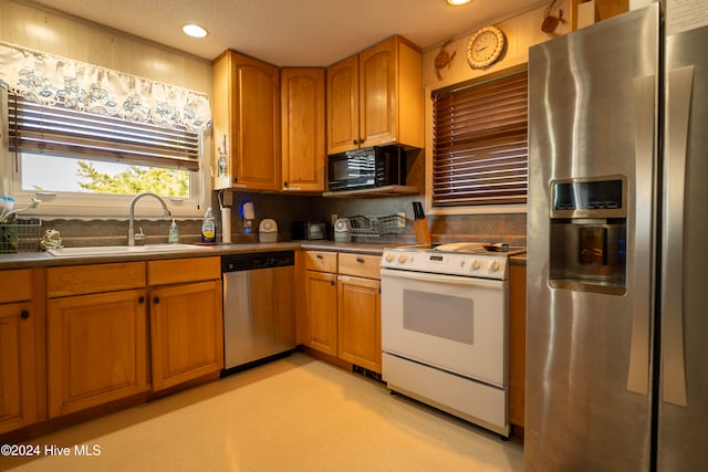 kitchen with appliances with stainless steel finishes, a textured ceiling, and sink