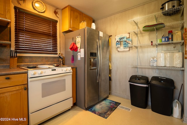 kitchen featuring stainless steel refrigerator with ice dispenser, a textured ceiling, and electric stove