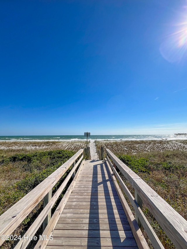 view of home's community with a water view and a view of the beach