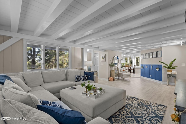 living room featuring beamed ceiling and wood-type flooring