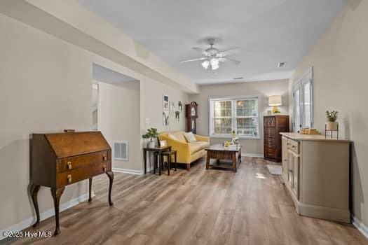 living area with ceiling fan and light hardwood / wood-style floors