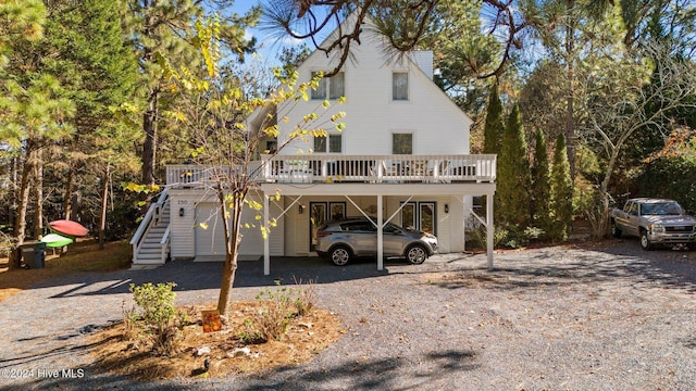 view of front of home with a deck and a carport