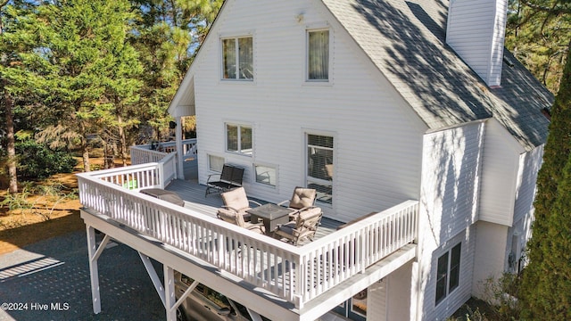 rear view of house with an outdoor living space and a wooden deck