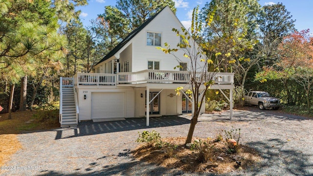 rear view of house featuring a deck and a garage