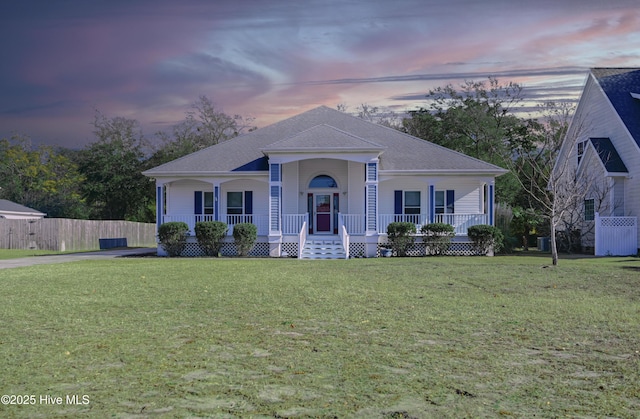 ranch-style house featuring a porch and a lawn