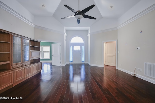 spare room featuring dark hardwood / wood-style flooring, a wealth of natural light, crown molding, and ceiling fan