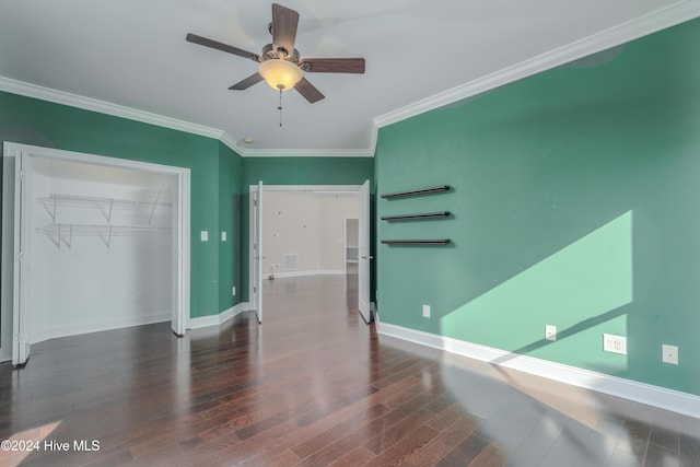 empty room featuring dark wood-type flooring, ceiling fan, and crown molding