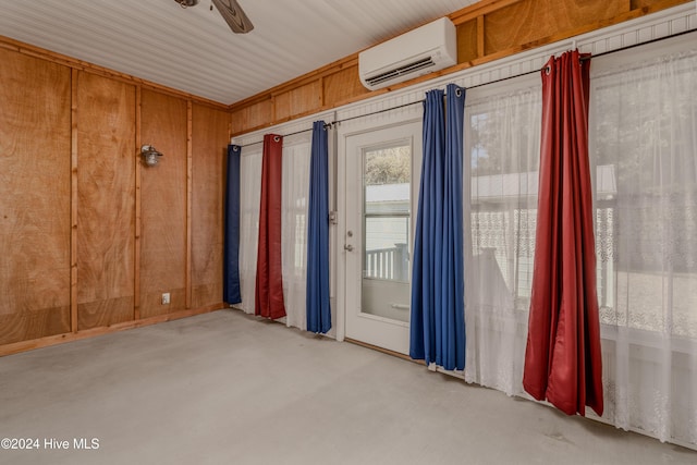 unfurnished room featuring a wall mounted air conditioner, ceiling fan, and wood walls