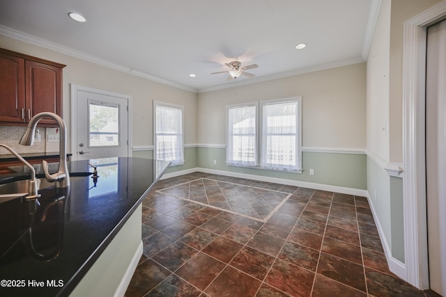 kitchen featuring decorative backsplash, appliances with stainless steel finishes, ornamental molding, ceiling fan, and sink