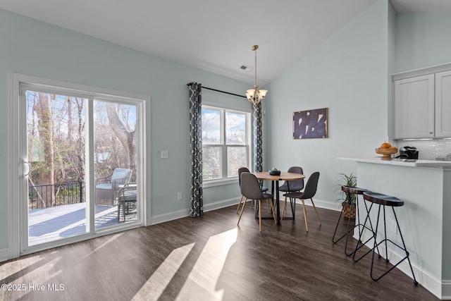 dining area featuring dark wood-type flooring, high vaulted ceiling, and a chandelier