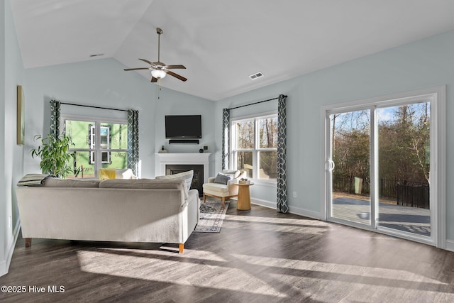 living room with lofted ceiling, a healthy amount of sunlight, and dark hardwood / wood-style floors