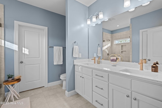 bathroom with a tile shower, vanity, tile patterned flooring, and toilet