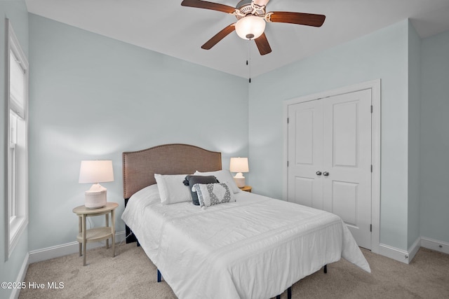 carpeted bedroom featuring ceiling fan and a closet