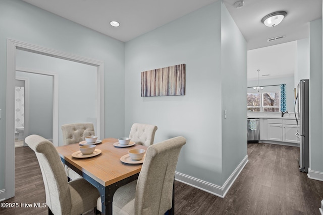 dining space with sink and dark wood-type flooring